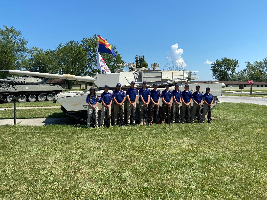 Juniors in front of a tank